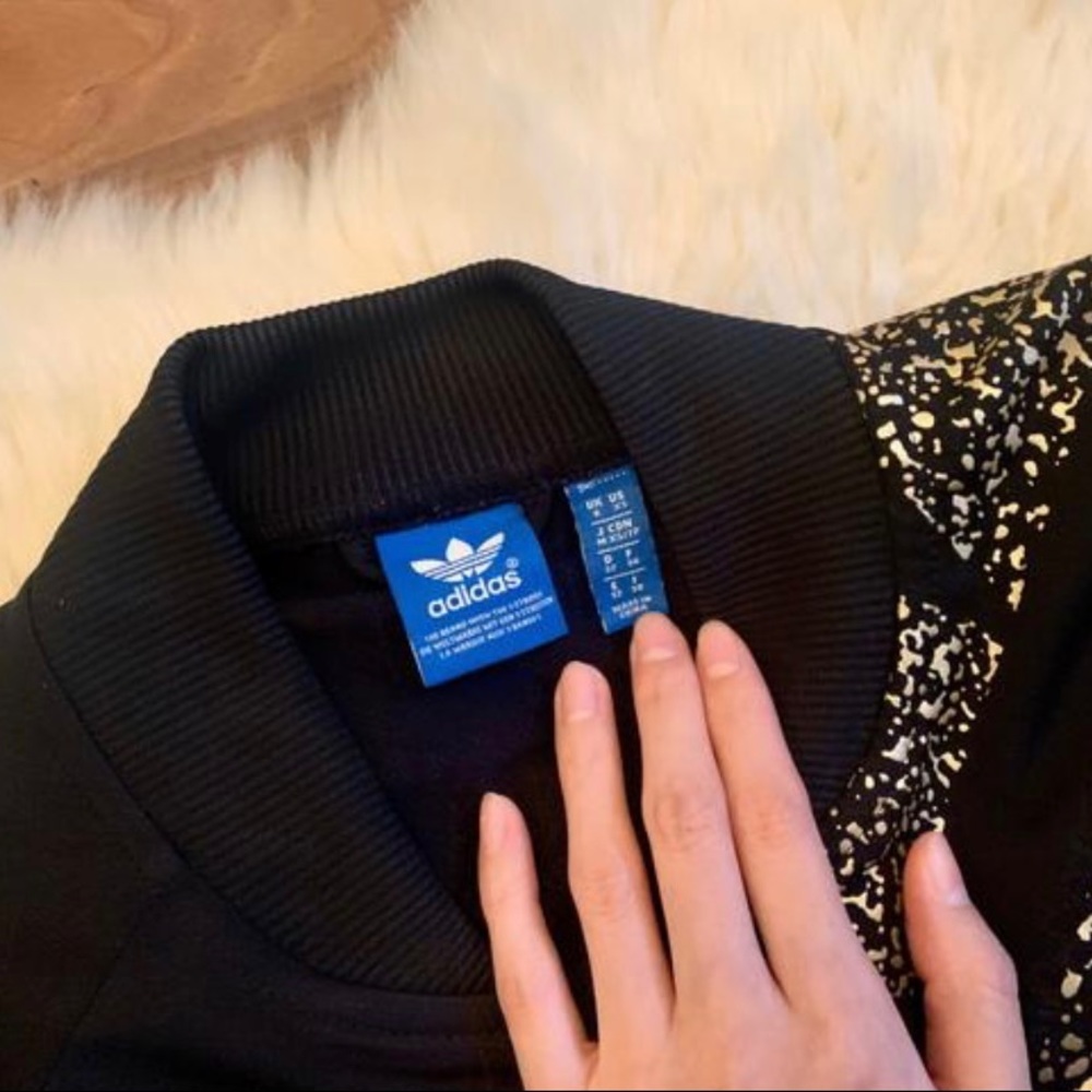 Adidas Originals Black and gold open sleeve track jacket.